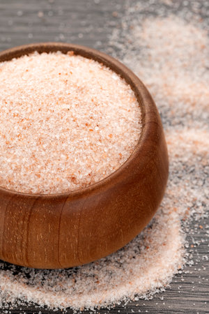 Himalayan pink salt in wooden bowl - Wood backgroundの写真素材