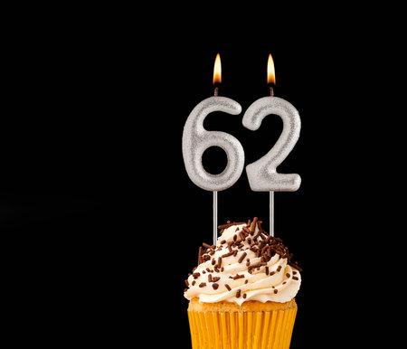Number 62 shaped candles - Birthday cupcake on black background.の写真素材