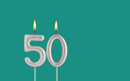 Birthday card on a green background - Candle in the shape of the number 50の写真素材