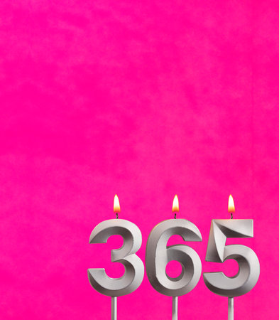 Three candles forming the number 365 - Fuchsia background.の写真素材