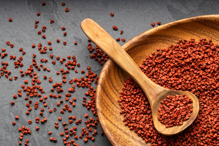 Bixa Orellana - Organic red annatto seeds in spoon and bowlの写真素材