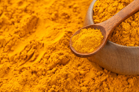 Organic turmeric powder in a spoon and bowl - Curcuma longa