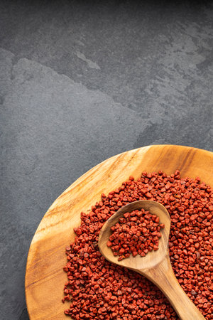 Bixa Orellana - Organic red annatto seeds in spoon and bowlの写真素材