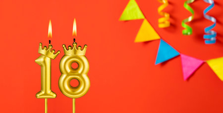 Number 18 candle - Birthday celebration on an orange background with pennantsの写真素材