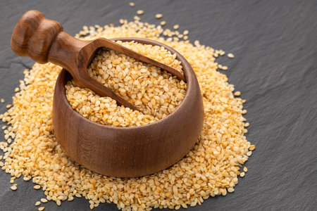 Raw organic sesame seeds in a spoon and bowl - Sesamum indicumの写真素材