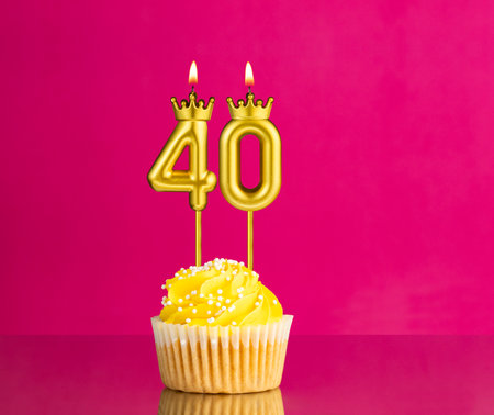 Yellow birthday cupcake with a number 40 candle - Birthday card on a pink background
