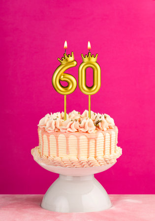 Pink birthday celebration cake with number 60 candleの写真素材