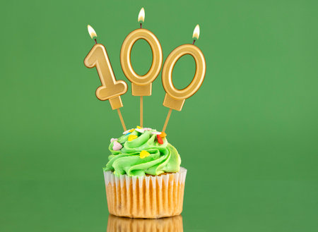 Birthday card with candle and cupcake - Number 100 on a green backgroundの写真素材