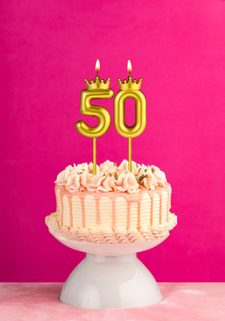 Pink birthday celebration cake with number 50 candleの写真素材