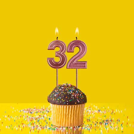 Birthday on a yellow background - Number 32 candleの写真素材