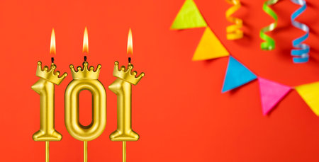 Number 101 birthday candle on an orange background with pennants