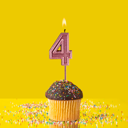 Birthday on a yellow background - Number 4 candleの写真素材