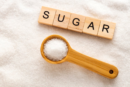 Fine crystals of refined white sugar on a wooden spoon - Saccharum officinarumの写真素材
