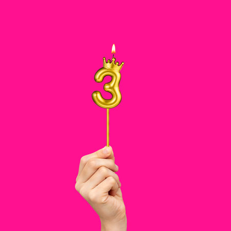 Birthday on a fuchsia background with the number 3 - Hands holding number-shaped candles