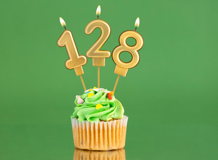 Birthday card with candle and cupcake - Number 128 on a green backgroundの写真素材