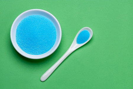 Fine blue salt crystals in a bowl and spoon