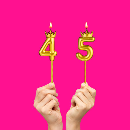 Birthday on a fuchsia background with the number 45 - Hands holding number-shaped candles