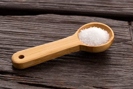 Fine grains of refined white sugar on a spoon - Saccharum officinarumの写真素材