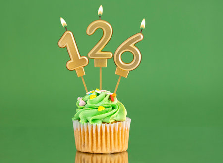 Birthday card with candle and cupcake - Number 126 on a green backgroundの写真素材