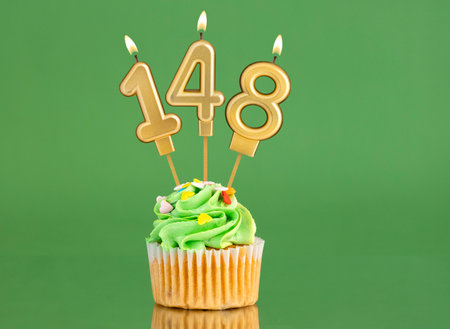 Birthday card with candle and cupcake - Number 148 on a green backgroundの写真素材