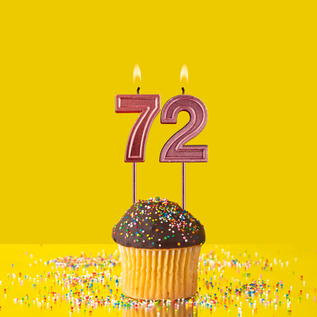 Birthday on a yellow background - Number 72 candleの写真素材