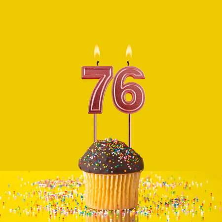 Birthday on a yellow background - Number 76 candleの写真素材