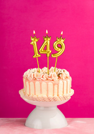 Number 149 birthday candle - Pink celebration cake with drip icingの写真素材