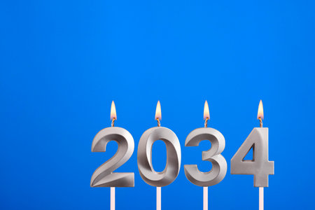 Achievements for the new year 2034 - Candles in the form of numbers burning on a blue background