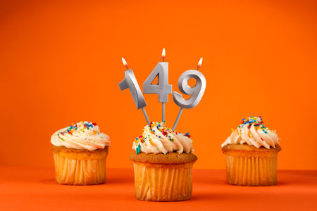 Candle number 149 - Celebration with birthday cupcake on orange background