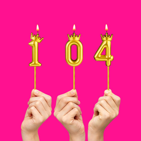 Hands holding number shaped candles - Birthday number 104