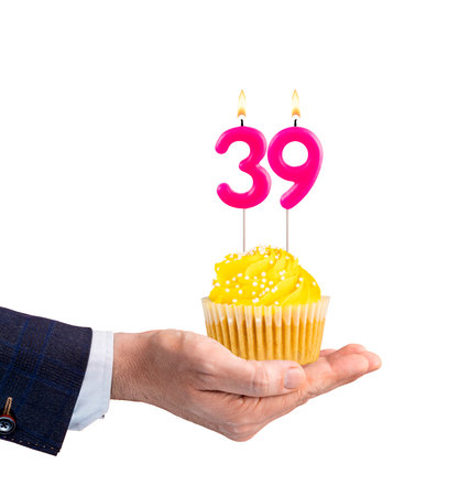 Hand holding a cupcake with a number 39 candle - Birthday on a white backgroundの写真素材