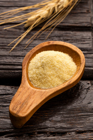 Wheat semolina in a wooden spoon - Triticumの写真素材