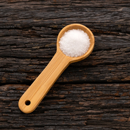Fine crystals of refined white sugar on a wooden spoon - Saccharum officinarumの写真素材
