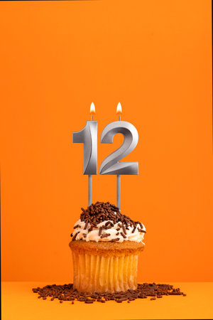 Number 12 candle - Birthday card design in orange background. cupcakeの写真素材