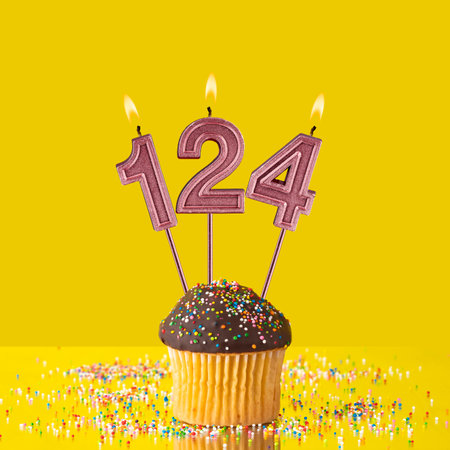 Birthday on a yellow background - Number 124 candleの写真素材