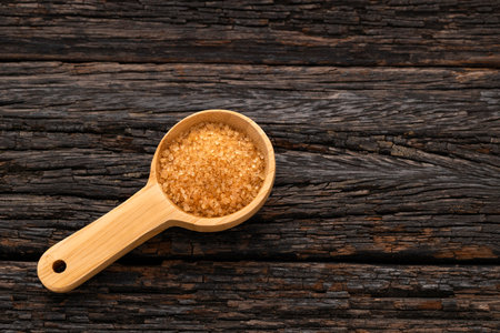 Saccharum officinarum - Organic brown sugar in a wooden spoonの写真素材