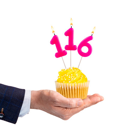 Hand holding a cupcake with a number 116 candle - Birthday on a white backgroundの写真素材