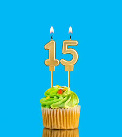 Candle number 15 - Birthday card with cupcake on blue backgroundの写真素材