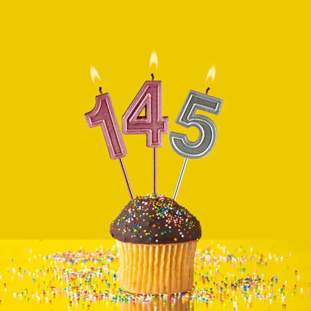 Candles forming the number 145 - Yellow background.の写真素材