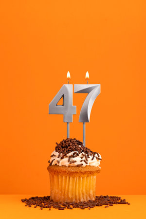 Birthday candle number 47 - Invitation card with orange background. cupcakeの写真素材