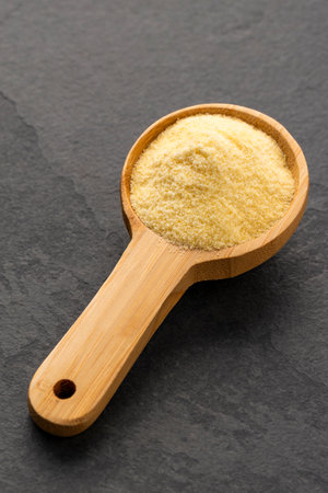 Triticum - Wheat semolina in a wooden spoonの写真素材