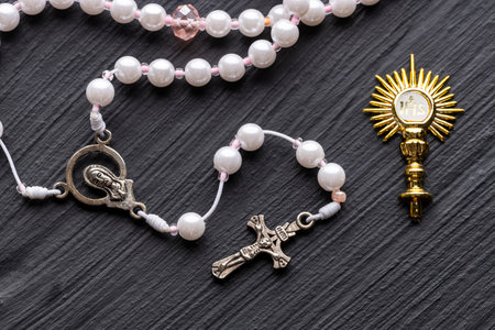Catholic rosary and Golden religious symbol with IHS monogram