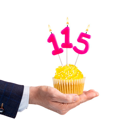 Hand holding a cupcake with a number 115 candle - Birthday on a white backgroundの写真素材