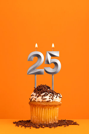 Birthday candle number 25 - Invitation card with orange background. cupcakeの写真素材