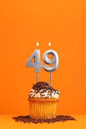 Birthday candle number 49 - Invitation card with orange background. cupcakeの写真素材