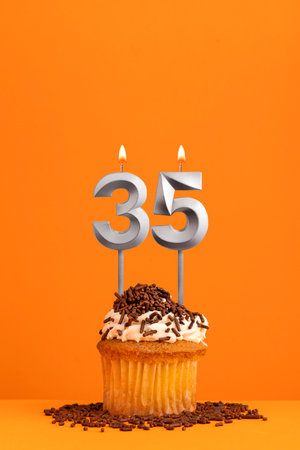 Birthday candle number 35 - Invitation card with orange background. cupcakeの写真素材