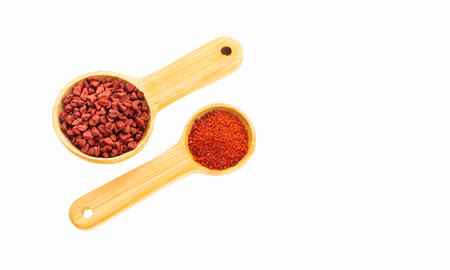 Ground or crushed annatto in two spoons - Bixa orellana