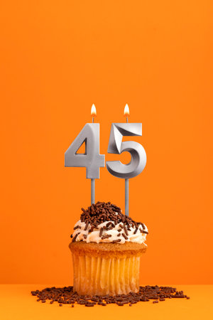 Birthday candle number 45 - Invitation card with orange background. cupcakeの写真素材