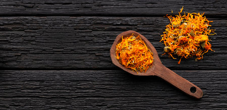Calendula flower petals on a wooden spoon - Calendula officinalisの写真素材