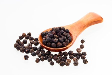 Black peppercorns in a wooden spoon - Piper nigrumの写真素材